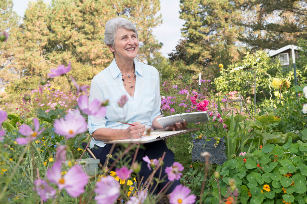 Senior woman painting in the garden