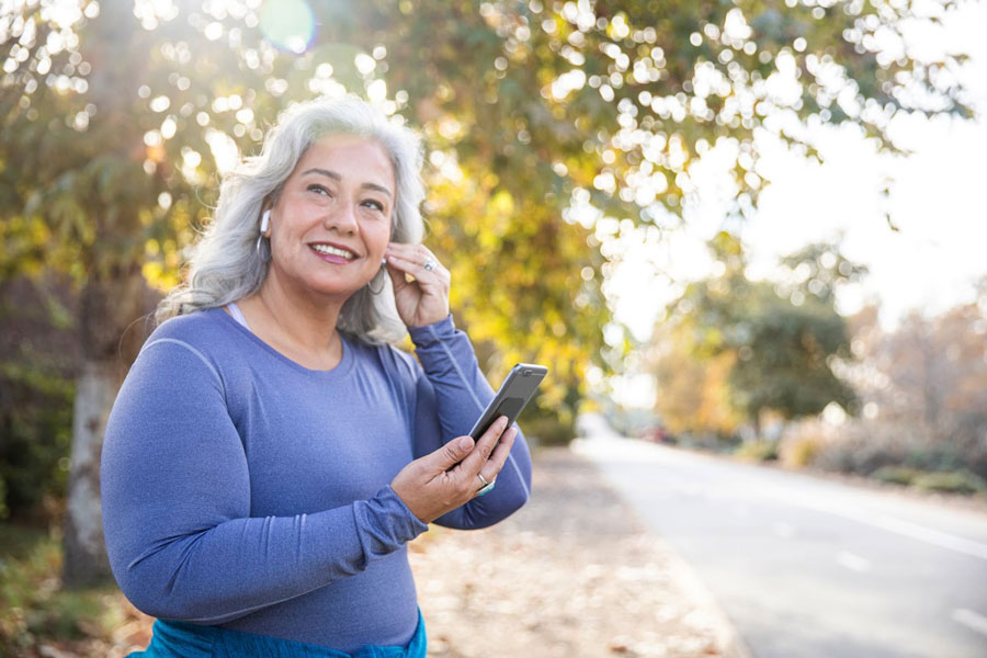 Senior woman listening to podcast