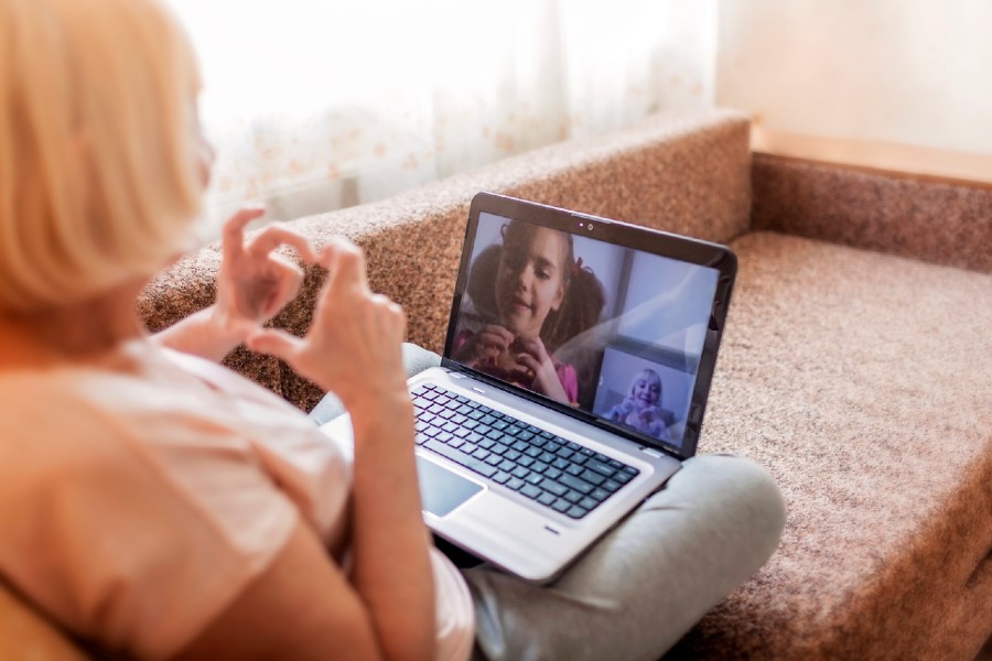 senior woman facetimes her grandchildren on her computer