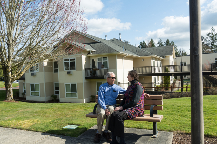 Senior couple enjoying the day, talking on a bench