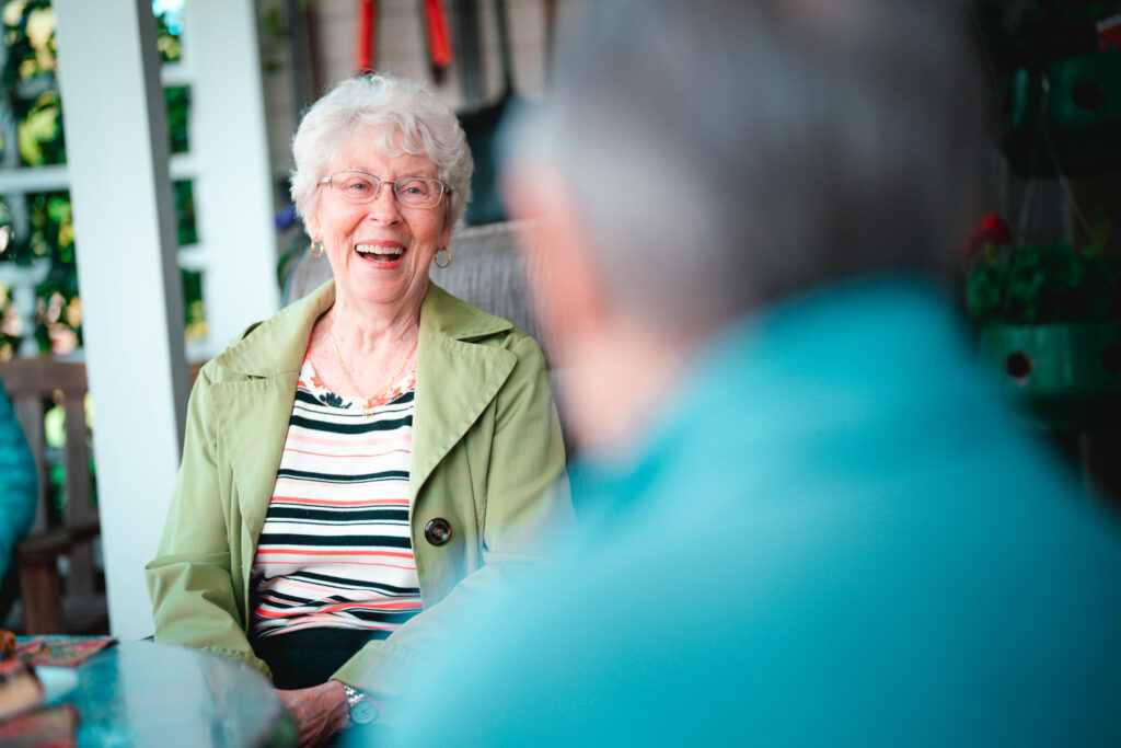 A senior woman laughs with friends